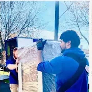 Two crew carrying a shrink-wrapped mattress out to the truck